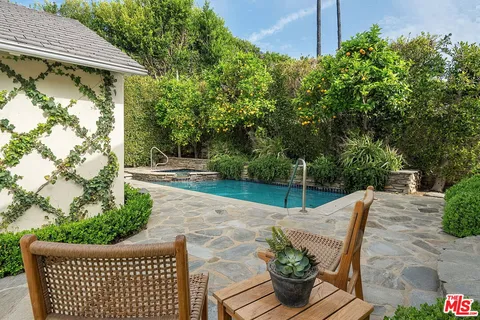 a view of a patio with table and chairs potted plants