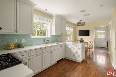a kitchen with sink cabinets and wooden floor
