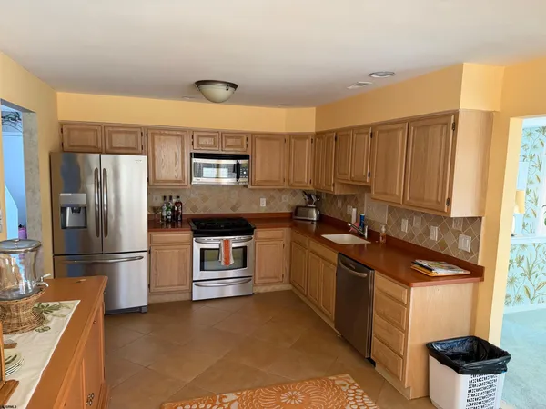 a kitchen with a sink refrigerator and microwave