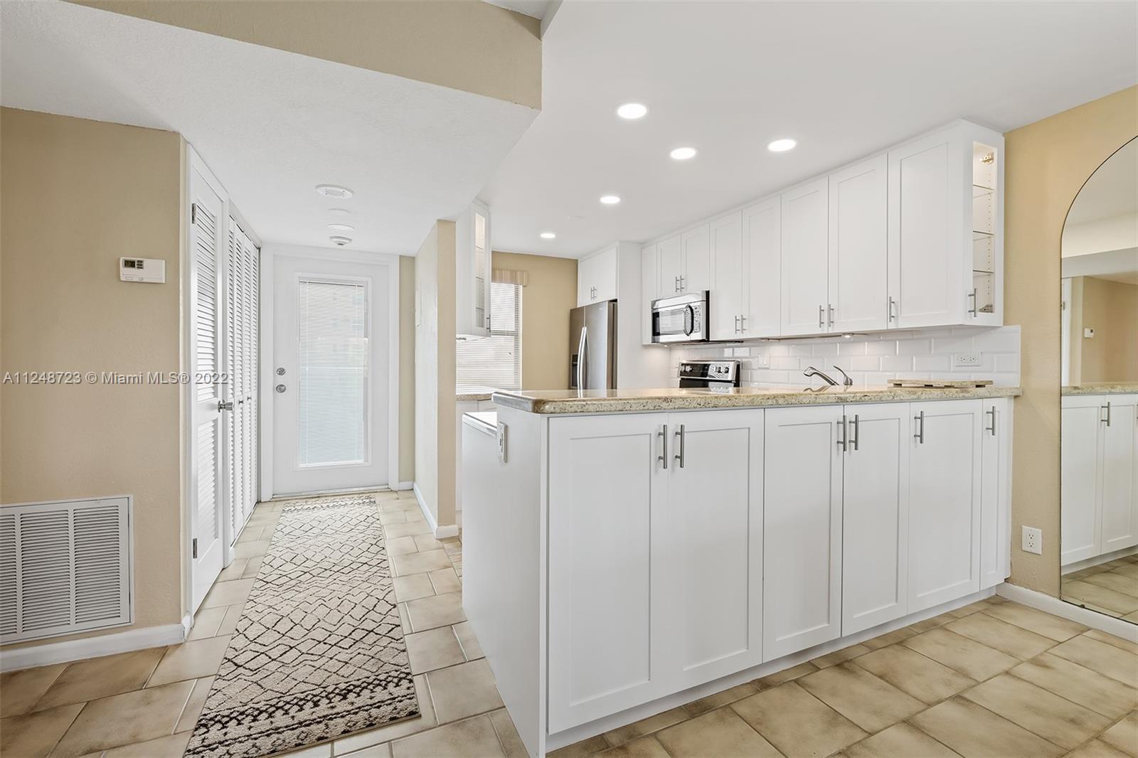 1401 North Riverside Drive, Unit 503 Pompano Beach, FL 33062 - Photo 13 of 30 a kitchen with white cabinets and refrigerator