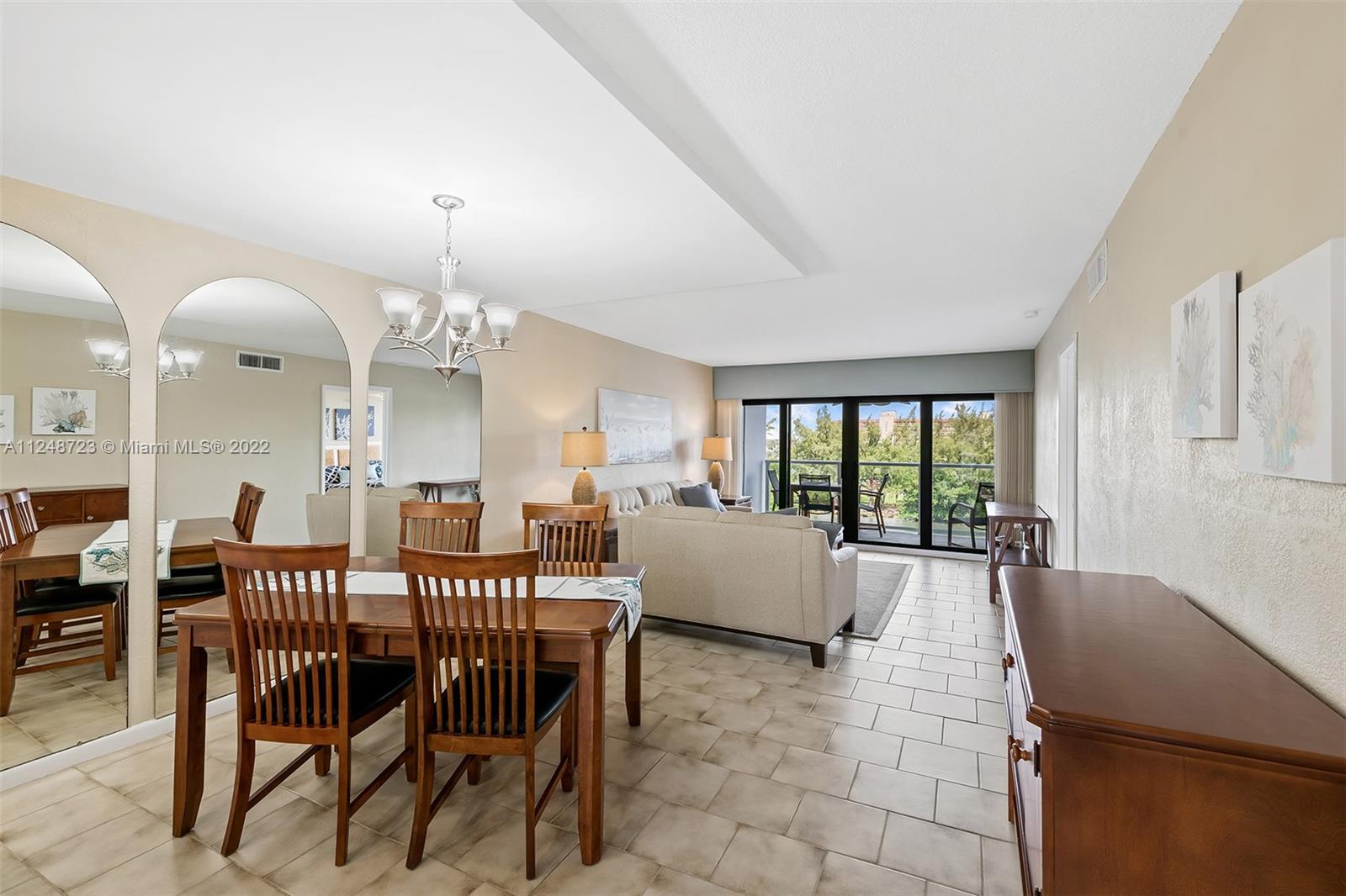 1401 North Riverside Drive, Unit 503 Pompano Beach, FL 33062 - Photo 8 of 30 a view of a dining room with furniture a chandelier and large windows