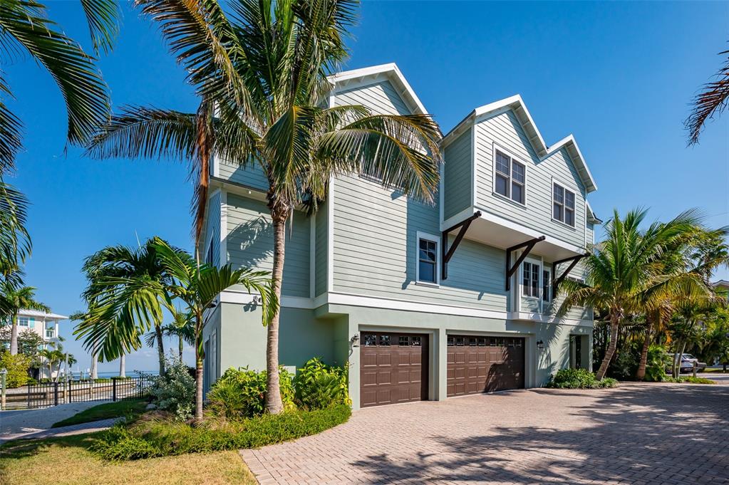526 56th Street Holmes Beach, FL 34217 - Photo 12 of 99 a front view of a house with a yard and palm trees