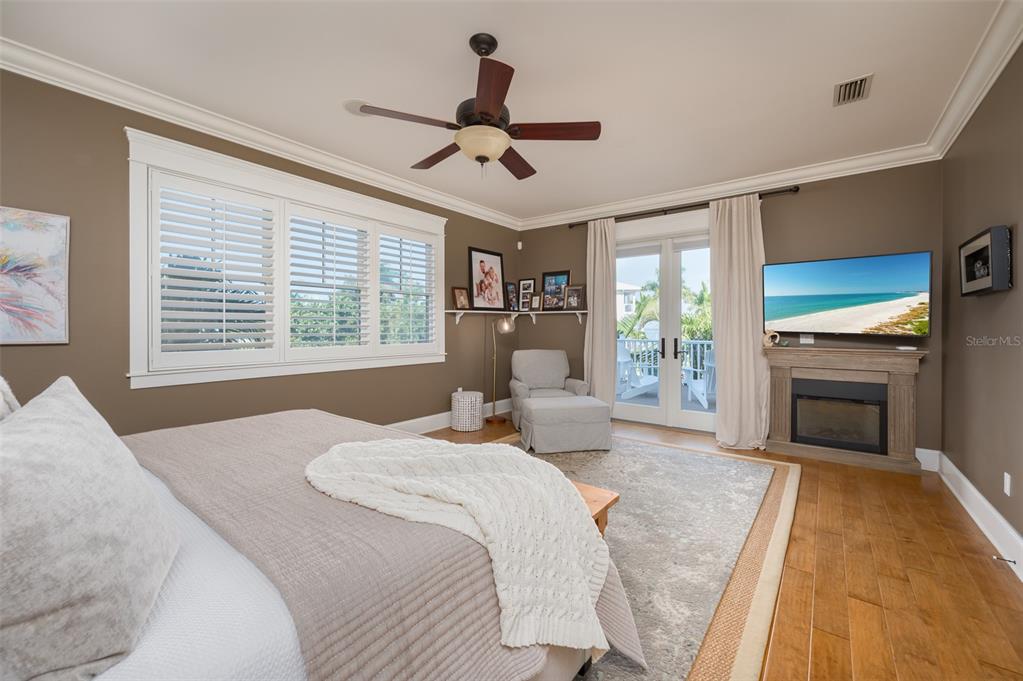 526 56th Street Holmes Beach, FL 34217 - Photo 34 of 99 a spacious bedroom with a large bed and a fireplace