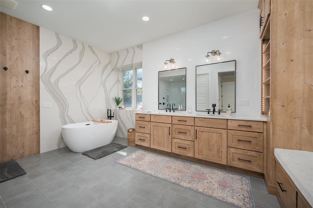 526 56th Street Holmes Beach, FL 34217 - Photo 36 of 99 a spacious bathroom with a double vanity sink mirror and a bathtub