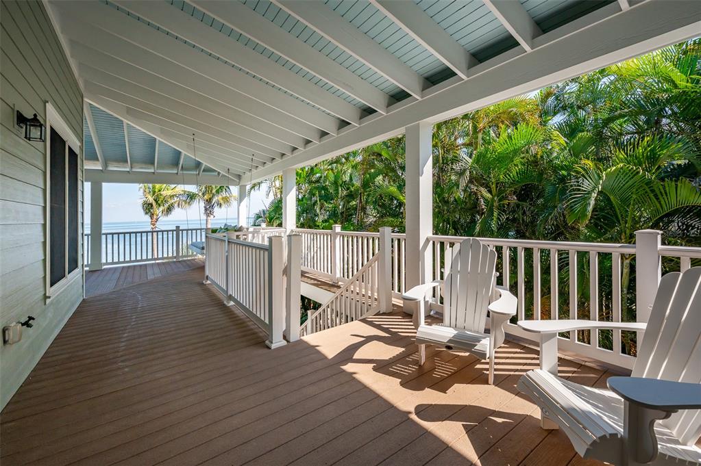 526 56th Street Holmes Beach, FL 34217 - Photo 74 of 99 a view of balcony with wooden floor and outdoor seating