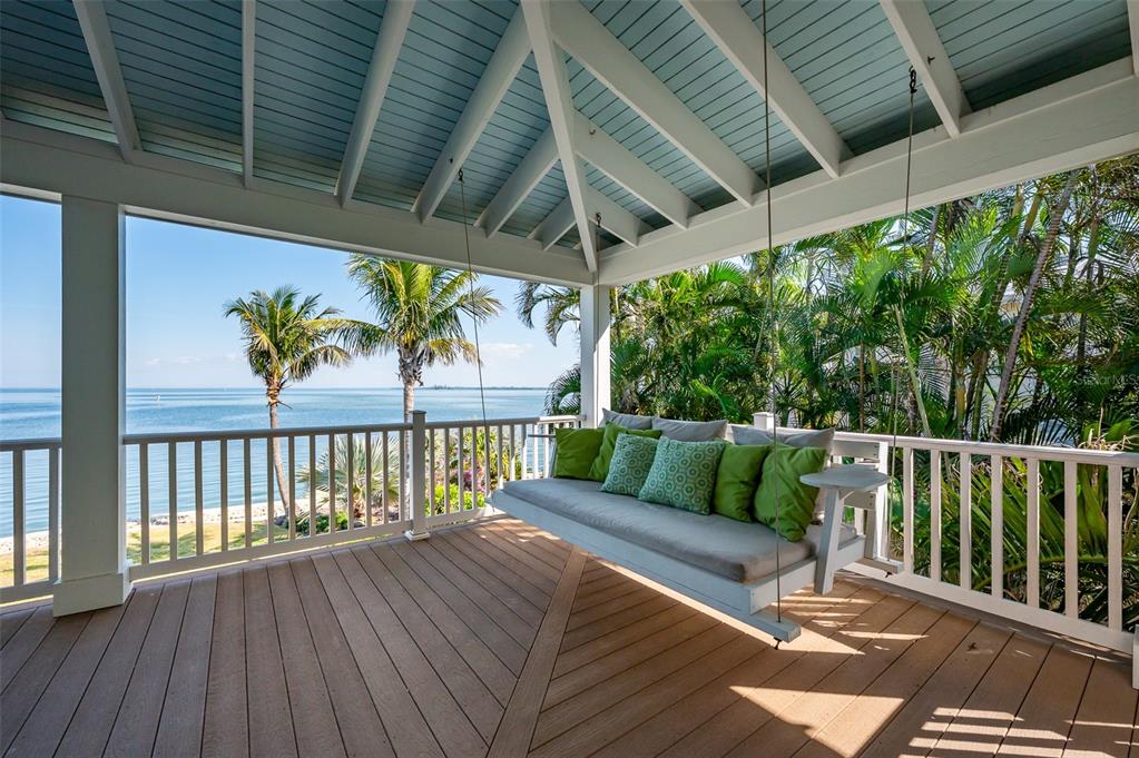 526 56th Street Holmes Beach, FL 34217 - Photo 75 of 99 a balcony with wooden floor outdoor seating and stairs