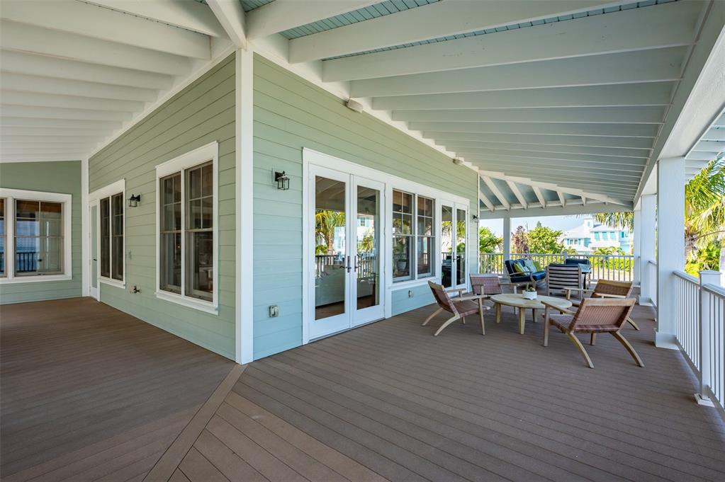526 56th Street Holmes Beach, FL 34217 - Photo 76 of 99 a view of a patio with table and chairs potted plants with wooden floor