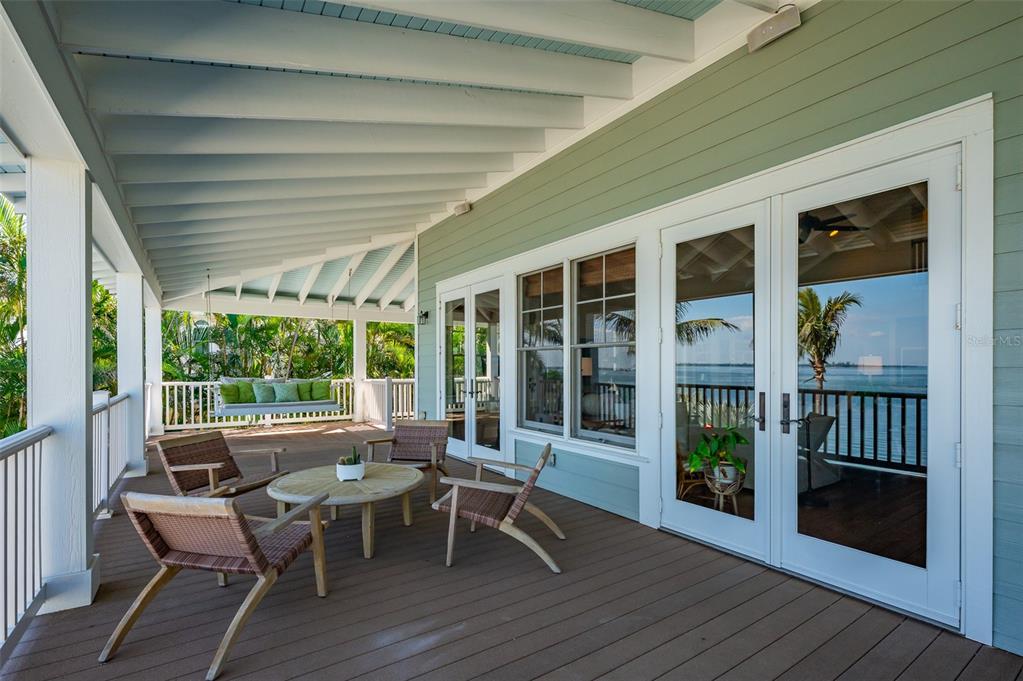 526 56th Street Holmes Beach, FL 34217 - Photo 77 of 99 a view of a deck with table and chairs and wooden floor