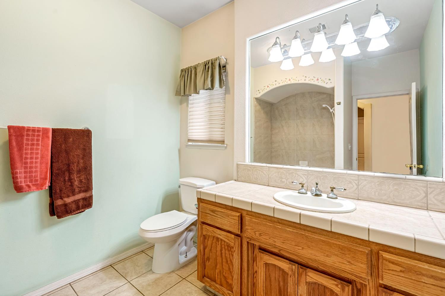 3410 Doubletree Way Madera, CA 93637 - Photo 26 of 34 a bathroom with a sink a toilet and a mirror