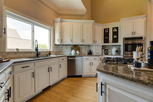 a view of a livingroom with a ceiling fan hardwood floor and a ceiling fan
