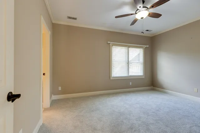 a view of an empty room with a chandelier fan