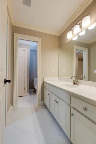 a bathroom with a granite countertop double vanity sink and mirror