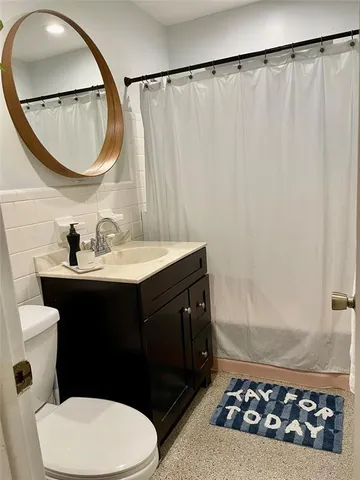 a bathroom with a sink vanity mirror and toilet