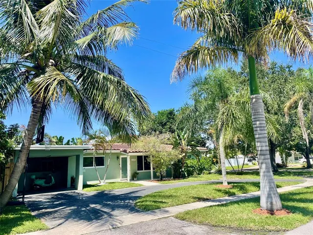 a front view of a house with a garden and trees