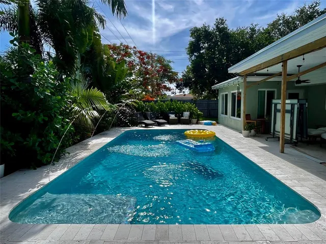 a swimming pool with outdoor seating and yard