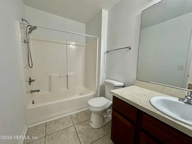 a bathroom with a granite countertop sink toilet a mirror and shower