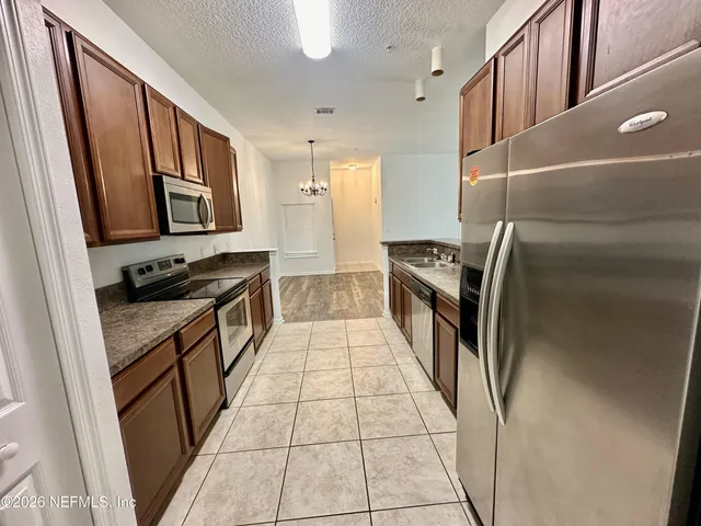 a kitchen with stainless steel appliances granite countertop a refrigerator and a stove