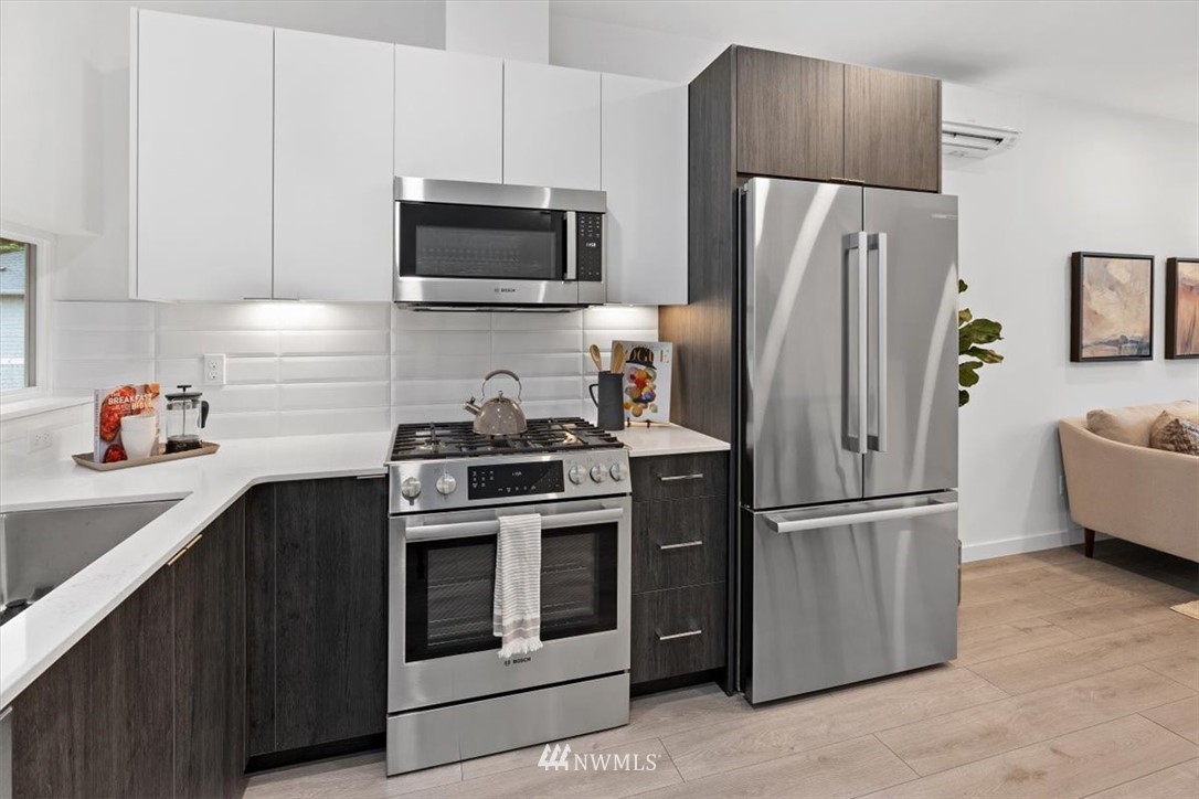 1271 North 145th Street Seattle, WA 98133 - Photo 13 of 32 a kitchen with stainless steel appliances a refrigerator stove and microwave
