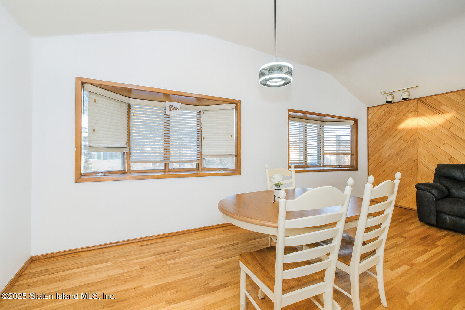 154 Merrill Avenue Staten Island, NY 10314 - Photo 9 of 21 a dining room with wooden floor a chandelier a wooden table and chairs
