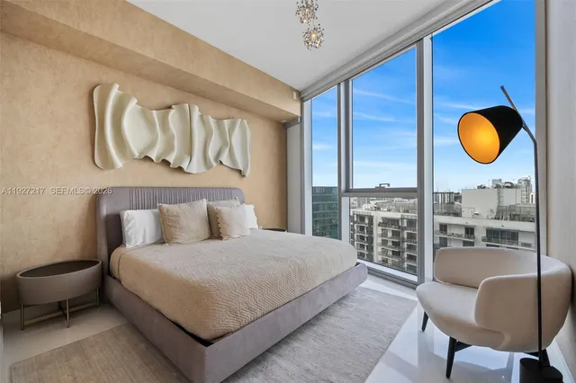 a bedroom with a bed and dresser with wooden floor