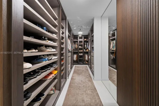 a view of walk in closet with clothes and shoes