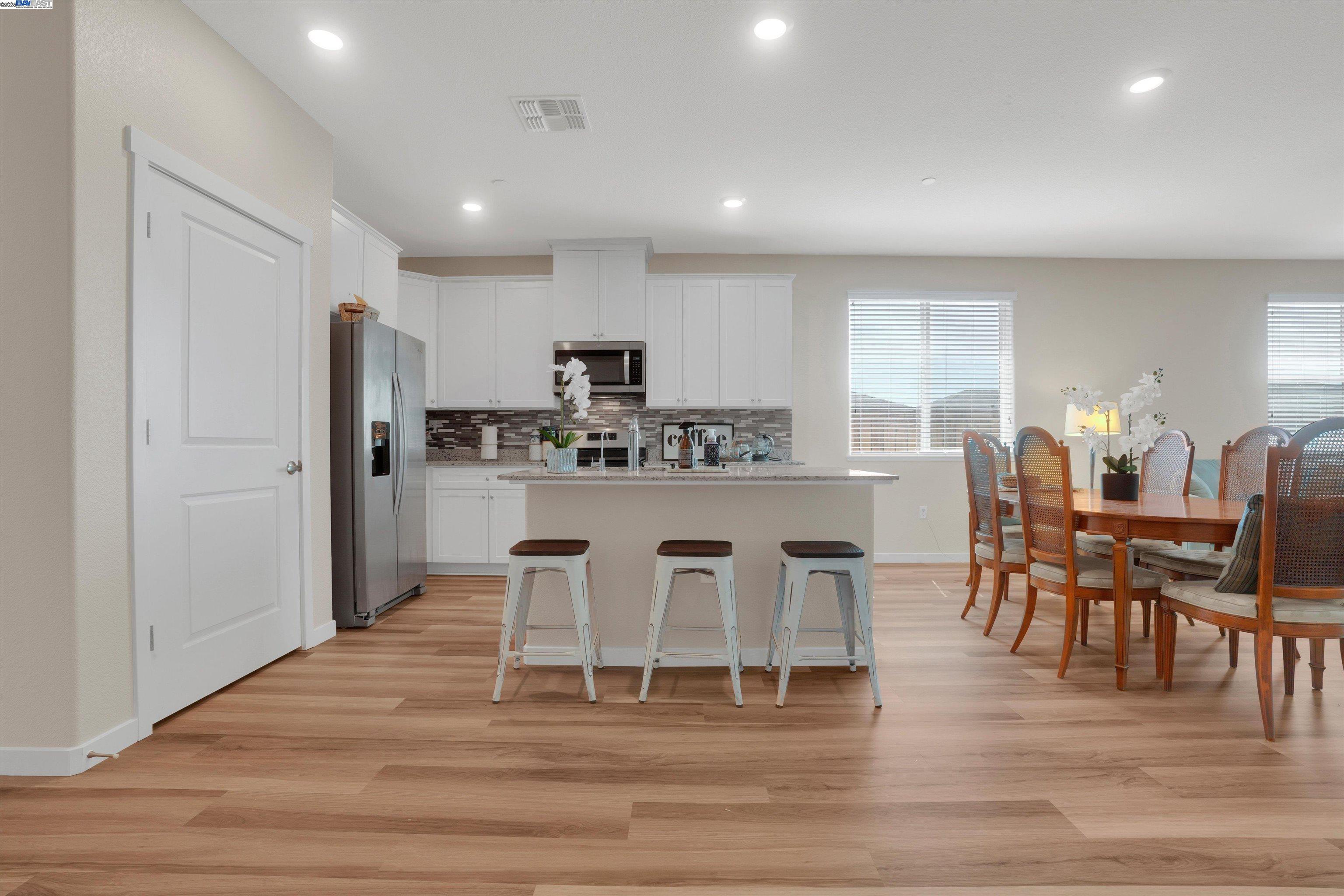 2211 Lavender Place Rio Vista, CA 94571 - Photo 11 of 36 a kitchen with stainless steel appliances kitchen island granite countertop a dining table chairs and a refrigerator