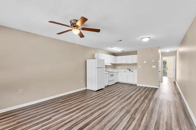 a view of empty room with wooden floor and window