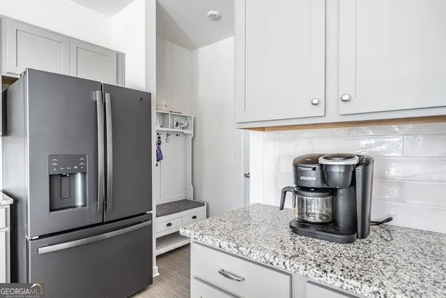 a kitchen with granite countertop a refrigerator and a sink