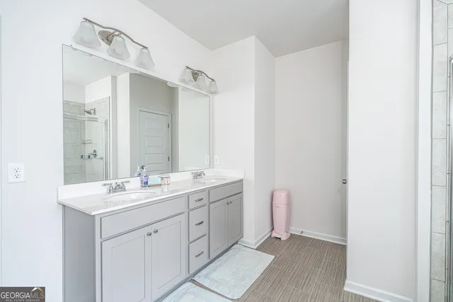 a spacious bathroom with a double vanity sink a mirror and a