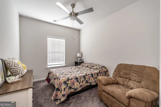 a bedroom with bed couch and window