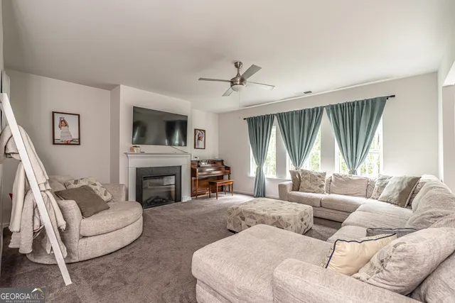 a living room with furniture a large window and a fireplace