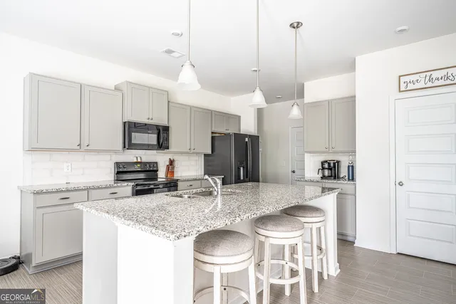 a kitchen with stainless steel appliances granite countertop a kitchen island a stove a table and chairs