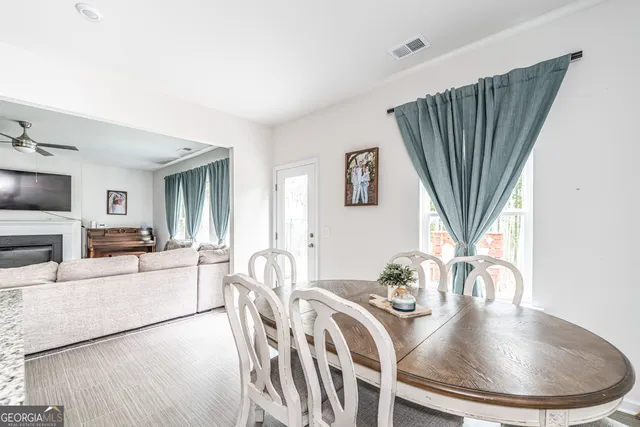 a dining room with furniture a fireplace and wooden floor