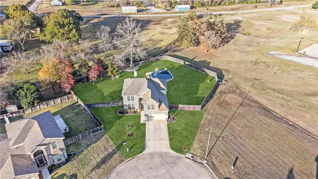 an aerial view of a house with a yard and lake view