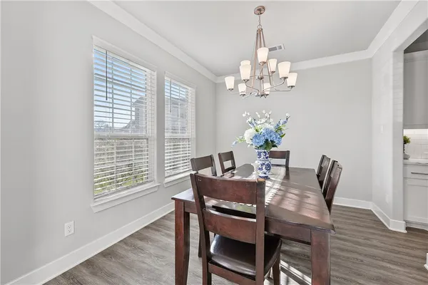 a view of a dining room with furniture a chandelier and wooden floor