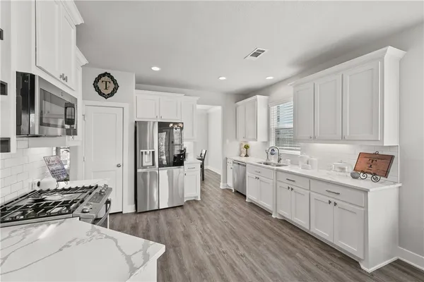 a kitchen with stainless steel appliances granite countertop a sink stove and refrigerator