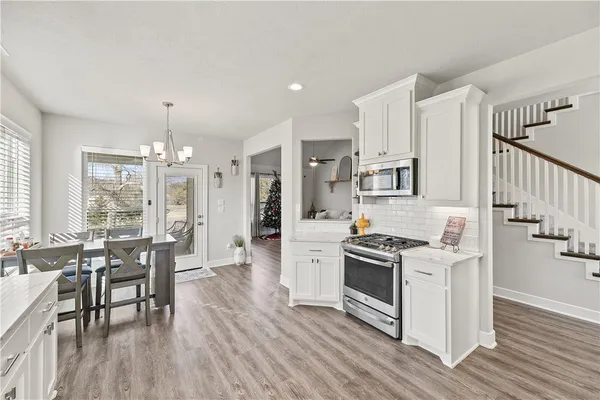 a kitchen with granite countertop a stove and a wooden floors