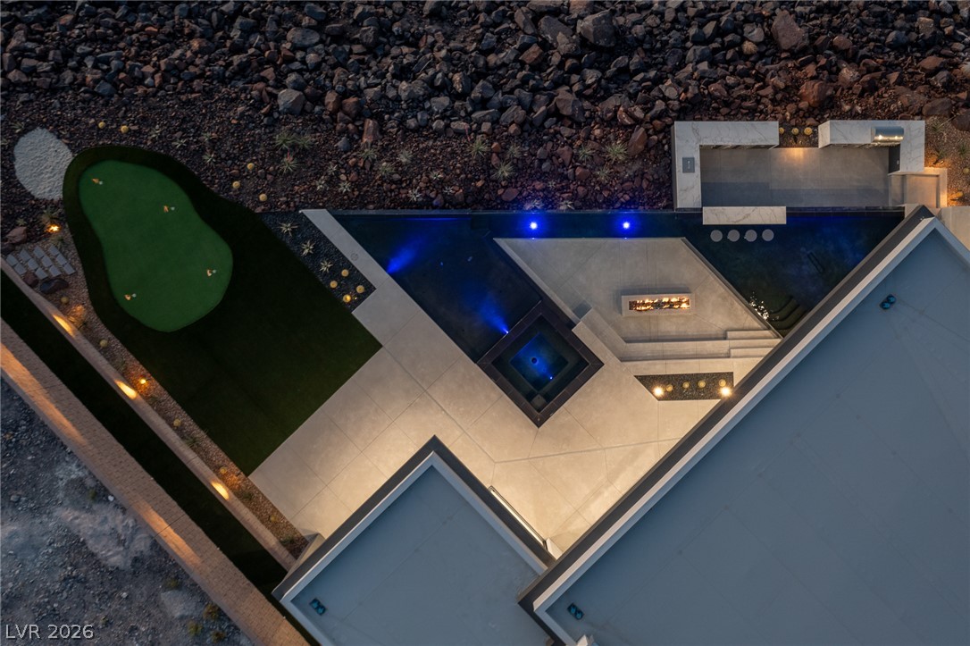 563 Grand Rim Drive Henderson, NV 89012 - Photo 58 of 70 An aerial perspective reveals a luxurious outdoor living space with a pristine pool and putting green.