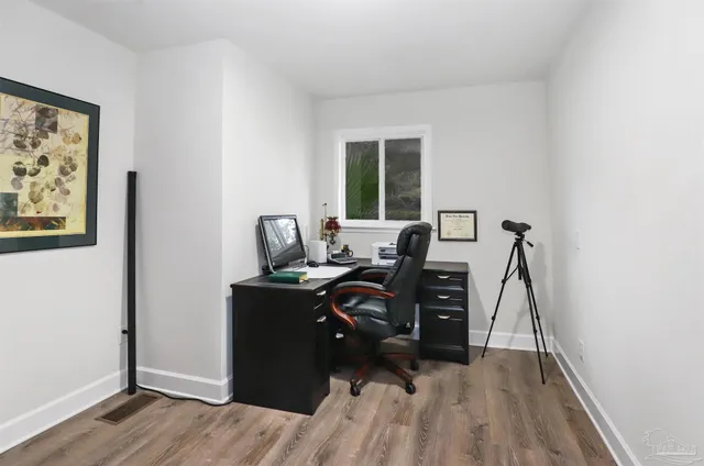 a view of workspace with wooden floor windows