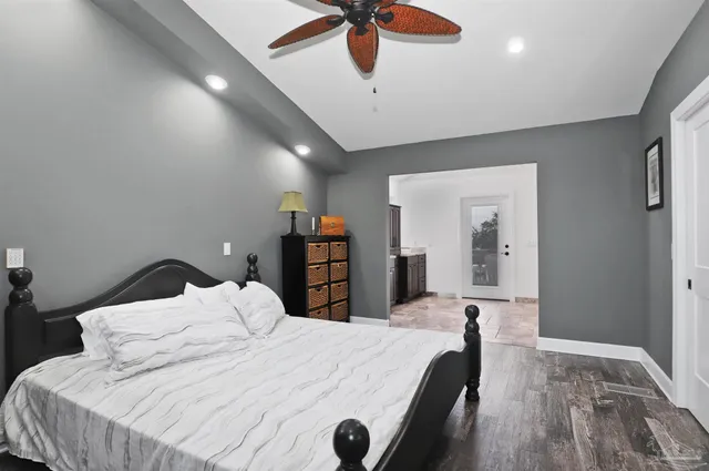 a bedroom with a bed and a dresser with rug