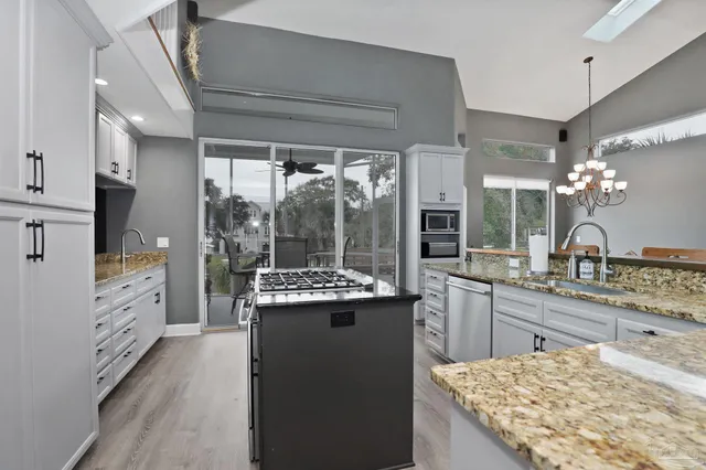 a kitchen with kitchen island granite countertop a sink stove and refrigerator