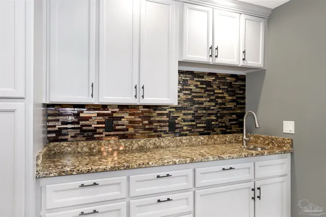 a kitchen with granite countertop white cabinets and white appliances
