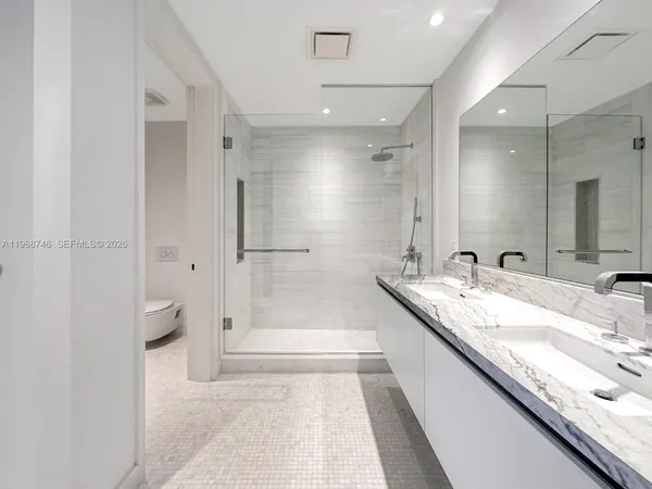 a bathroom with a granite countertop bathtub sink and mirror