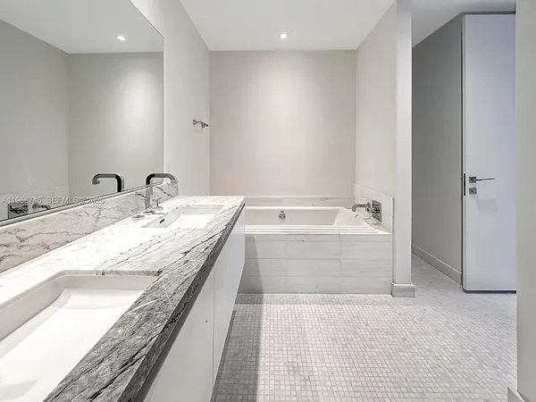 a bathroom with a double vanity sink mirror and shower