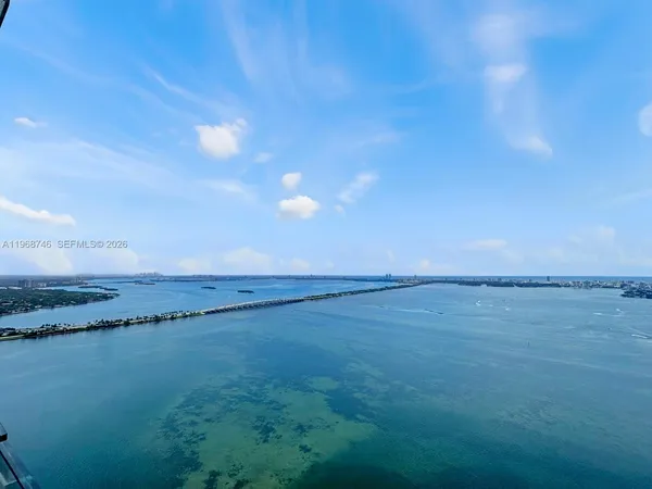 a view of a big room with wooden floor and windows