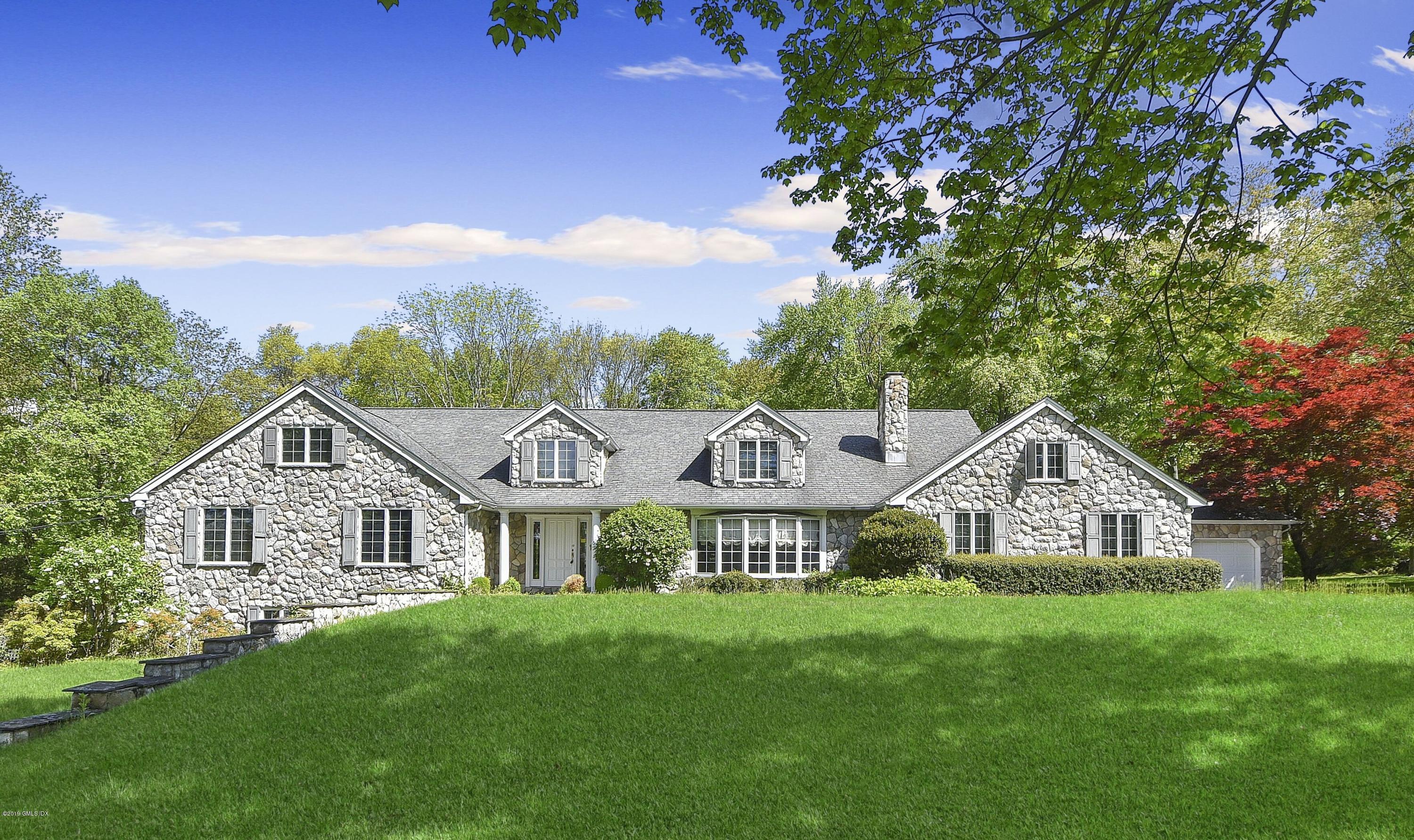 a view of a house with a big yard and large trees
