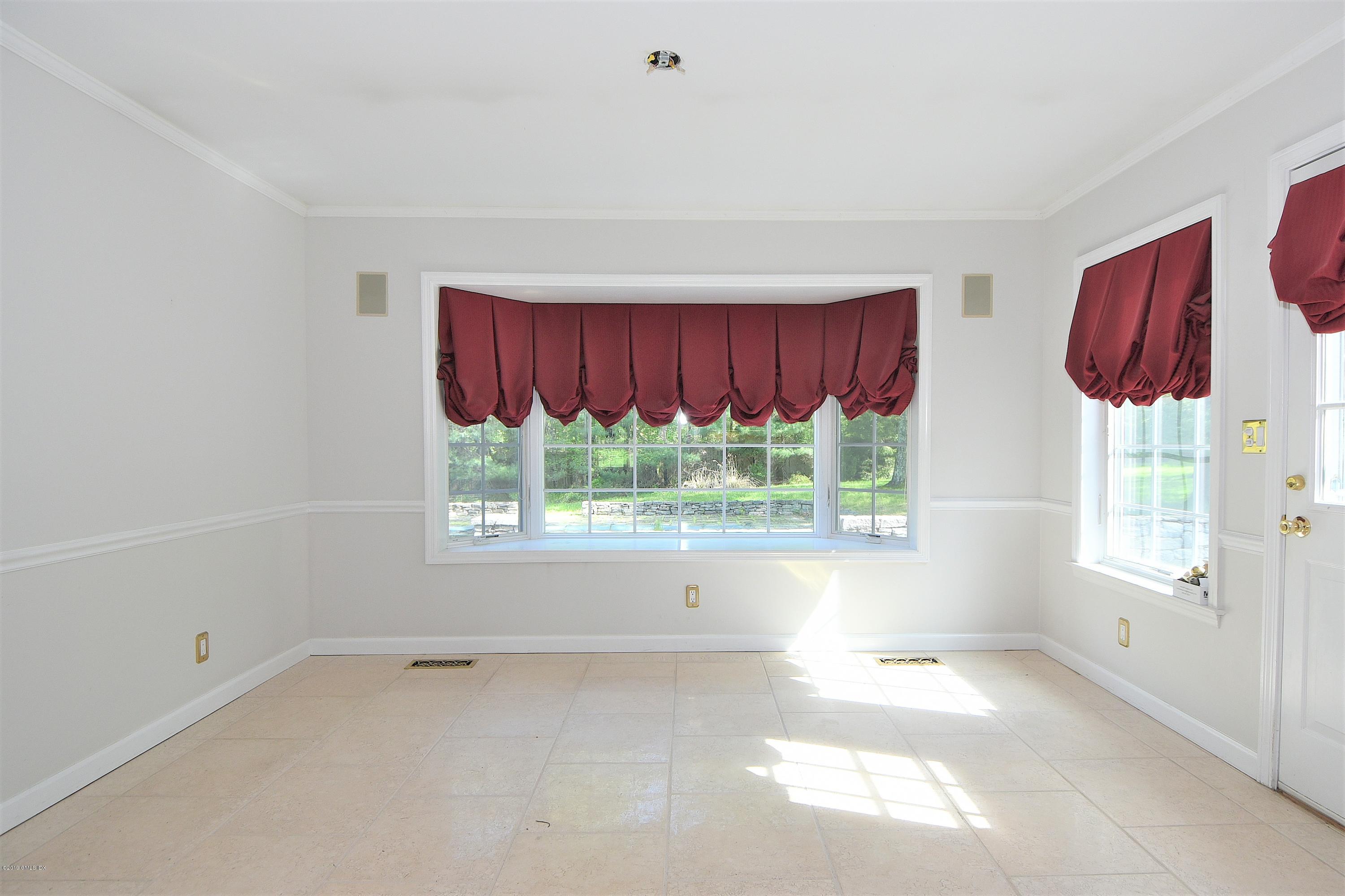 1 Tinker Lane Greenwich, CT 06830 - Photo 15 of 30 a view of an empty room with a window and a ceiling fan