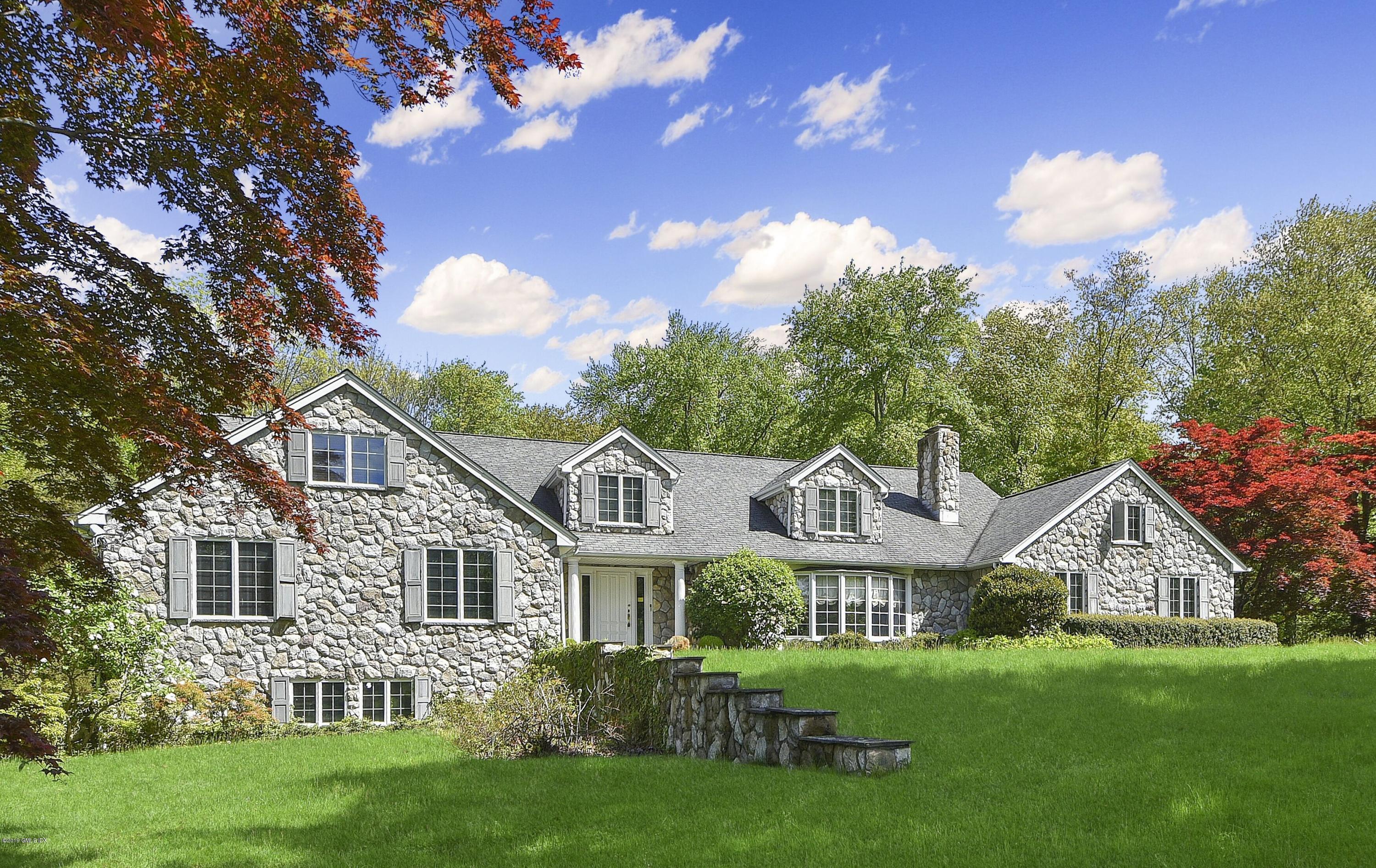 1 Tinker Lane Greenwich, CT 06830 - Photo 2 of 30 a front view of a house with a garden and porch