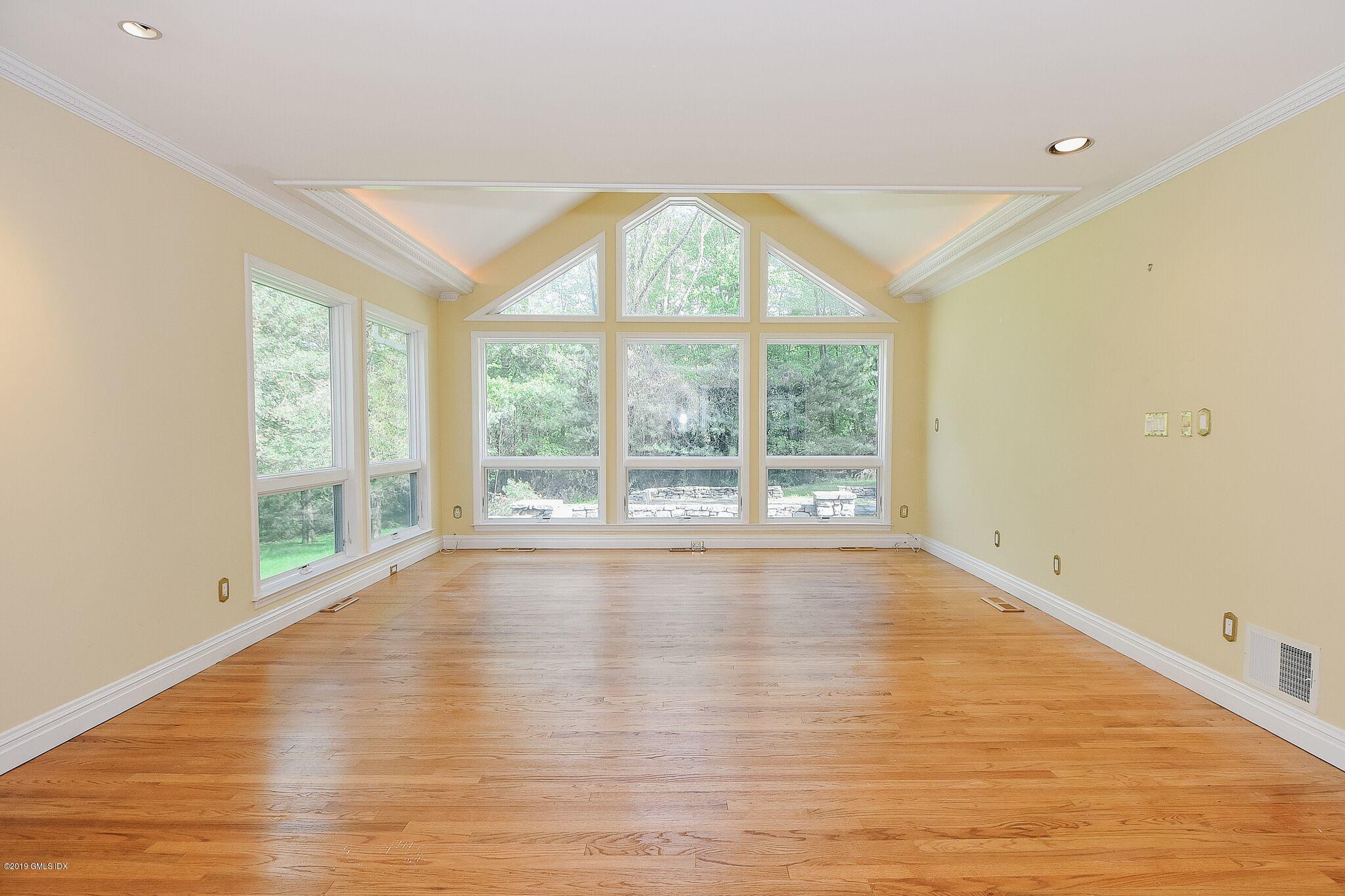 1 Tinker Lane Greenwich, CT 06830 - Photo 6 of 30 a view of an empty room with wooden floor and a window
