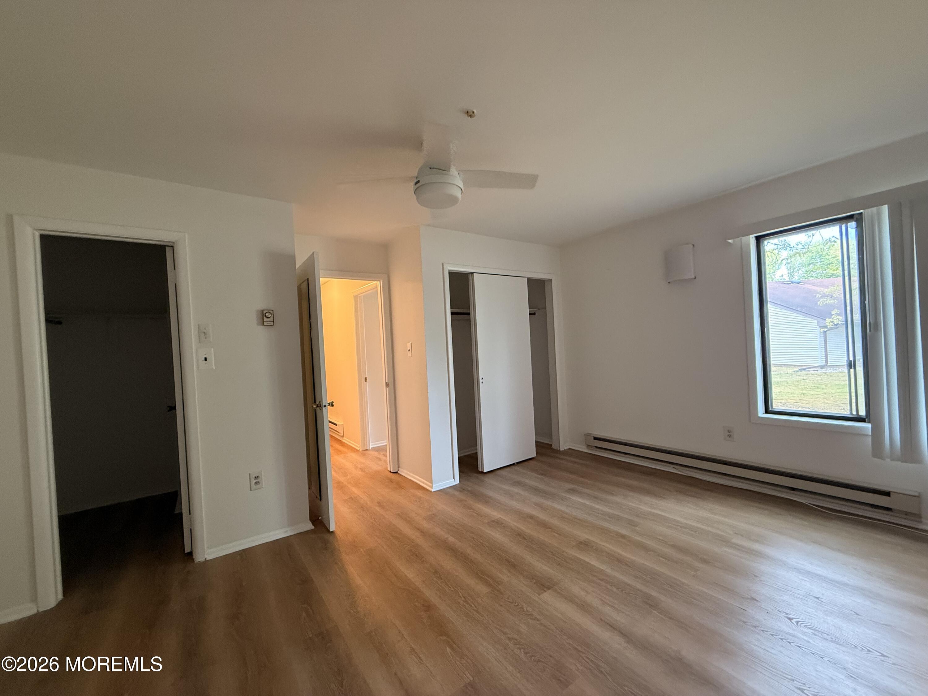 79 Overlook Way, Unit D Manalapan, NJ 07726 - Photo 12 of 13 an empty room with wooden floor and windows